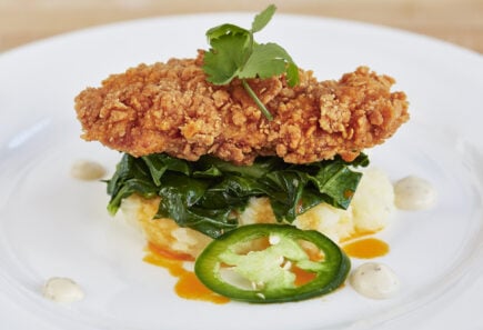 A battered and fried cultured meat, a cultured chicken cutlet, plated with sauteed greens and mashed root vegetables | image courtesy of upside foods