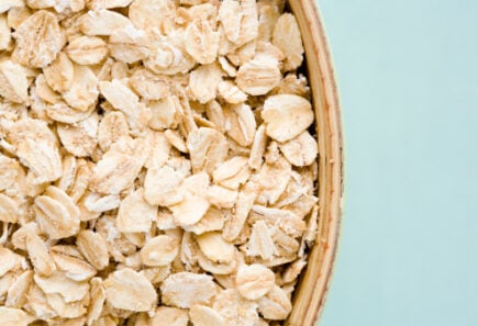 Oats in a bowl against a blue background, a possible new ingredient for plant-based meat
