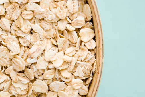Oats in a bowl against a blue background, a possible new ingredient for plant-based meat