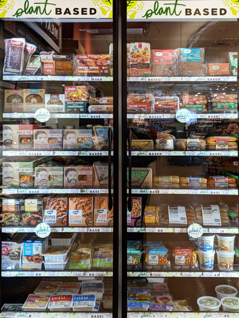 Door signage and shelf tags demarcate plant-based foods in the heinen’s refrigerated section.