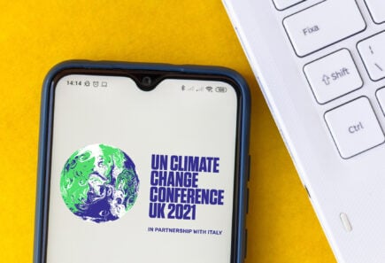Illustration of the 2021 united nations climate change conference (cop26) logo seen displayed on a smartphone