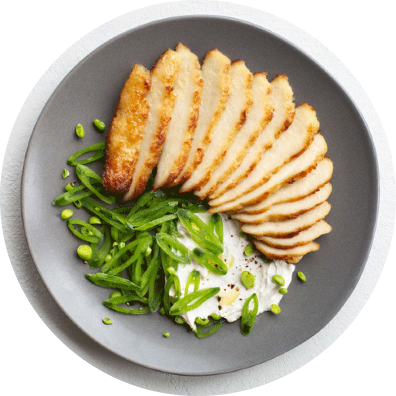 Grilled cultured meat, cultured chicken by upside foods sliced and plated with a puree and scallions on a grey plate